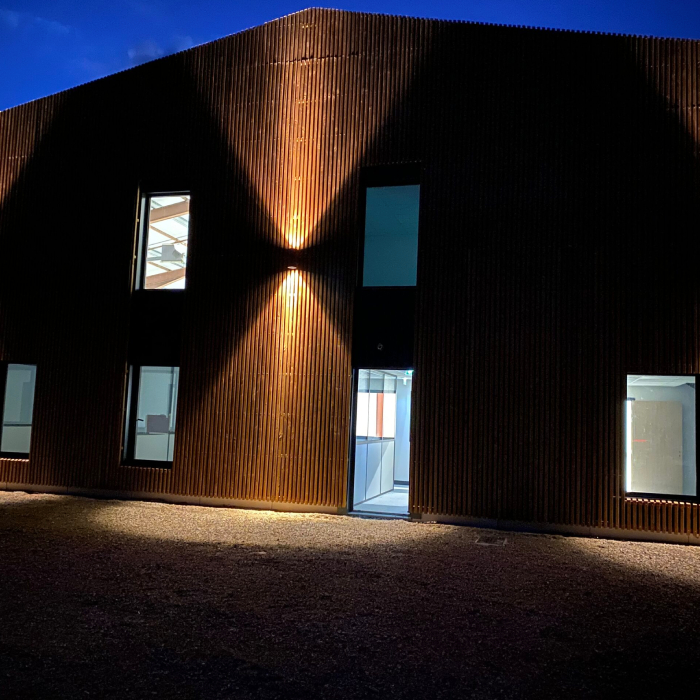 Éclairage architectural de façade réalisé par A.M Elec, valorisation d’un bâtiment professionnel en soirée